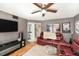 Cozy living room featuring a red leather sofa, entertainment center, and a ceiling fan at 799 Fairwood Ln, Clearwater, FL 33759