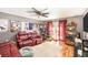 Inviting living room featuring a red leather sofa, ceiling fan, and sliding glass doors at 799 Fairwood Ln, Clearwater, FL 33759