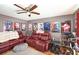 Comfortable living room with a ceiling fan, red leather couches, and movie-themed wall art at 799 Fairwood Ln, Clearwater, FL 33759