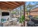 Screened patio featuring dark wood beam architecture, outdoor furniture and decorative lighting at 799 Fairwood Ln, Clearwater, FL 33759