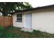 Exterior entrance to the home with a wooden fence and lush vegetation at 8319 N 14Th St, Tampa, FL 33604