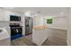Modern kitchen with stainless steel appliances, white cabinetry, island and wood-look flooring at 8319 N 14Th St, Tampa, FL 33604