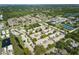 Expansive aerial view of a well-maintained neighborhood with lush green landscaping and community amenities at 858 Cambridge Ct # 858, Dunedin, FL 34698