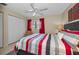 Comfortable bedroom with ceiling fan, window, closet, and a queen bed, creating a cozy retreat at 858 Cambridge Ct # 858, Dunedin, FL 34698