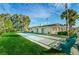 Bright and sunny bocce ball court with lush green grass and benches, next to clubhouse at 858 Cambridge Ct # 858, Dunedin, FL 34698