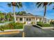 Charming clubhouse entrance with palm trees, manicured landscaping, and ample parking at 858 Cambridge Ct # 858, Dunedin, FL 34698