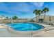 Sparkling community pool surrounded by palm trees and lounge chairs for sunny relaxation at 858 Cambridge Ct # 858, Dunedin, FL 34698