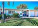 Charming single-story home with a well-maintained lawn and a cozy front porch seating area at 858 Cambridge Ct # 858, Dunedin, FL 34698
