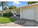 Charming single-story home with a well-maintained lawn, complemented by lush landscaping and bright blue patio chairs at 858 Cambridge Ct # 858, Dunedin, FL 34698