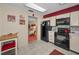Well-lit kitchen featuring black appliances, white cabinets, and access to the living room at 858 Cambridge Ct # 858, Dunedin, FL 34698