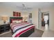 Comfortable bedroom with striped bedding, ceiling fan, and ensuite bathroom at 858 Cambridge Ct # 858, Dunedin, FL 34698