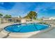 Community pool with a screened-in lanai, tables, and umbrellas for residents to enjoy poolside relaxation at 858 Cambridge Ct # 858, Dunedin, FL 34698