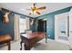 Stylish home office with dark green walls, wooden desk, and charming decor, creating a productive and inviting workspace at 9550 134Th St, Seminole, FL 33776