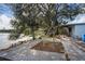 Backyard featuring a brick walkway, lush trees, and tranquil lake view at 1214 Stover Ct, Holiday, FL 34691