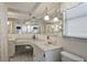 Bright bathroom features a large mirror, vanity, sink and toilet at 1214 Stover Ct, Holiday, FL 34691