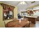 Charming dining area with a round table and chairs, opening to the kitchen with a breakfast bar at 1214 Stover Ct, Holiday, FL 34691