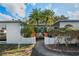 Inviting walkway that leads to the entrance, framed by tropical plants at 1214 Stover Ct, Holiday, FL 34691