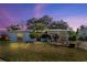 Exterior view of the house showcasing lush landscaping and trees at 1214 Stover Ct, Holiday, FL 34691