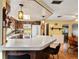 Open kitchen featuring a breakfast bar, white appliances, and wood cabinets at 1214 Stover Ct, Holiday, FL 34691