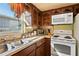 Well-lit kitchen featuring wood cabinets, a window, and modern appliances at 1214 Stover Ct, Holiday, FL 34691