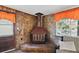 Cozy living room with a stone fireplace, wood accents, and bright windows overlooking the lake at 1214 Stover Ct, Holiday, FL 34691