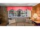Comfortable living room with stone wall accents, lake views, and ample natural light at 1214 Stover Ct, Holiday, FL 34691