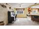 Bright office area open to kitchen, featuring brick accents, desk, and comfortable seating at 1214 Stover Ct, Holiday, FL 34691