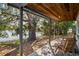 Covered patio featuring brick flooring, wooden chairs, and scenic lake view at 1214 Stover Ct, Holiday, FL 34691