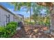 Secluded backyard with mature trees, leads to a serene lake view, adjacent to a screened lanai with privacy fence at 10218 Garden Alcove Dr, Tampa, FL 33647