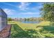 Lush green lawn leads to a tranquil lake view, enhanced by mature trees and privacy, adjacent to screened lanai at 10218 Garden Alcove Dr, Tampa, FL 33647