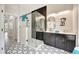 Stylish bathroom features a glass-enclosed shower, dual vanities, and black and white tile at 10218 Garden Alcove Dr, Tampa, FL 33647