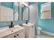 Stylish blue bathroom with dual vanities, modern fixtures, and a clean design at 10218 Garden Alcove Dr, Tampa, FL 33647
