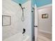 Modern bathroom featuring a marble-tiled shower, black fixtures, and open entry at 10218 Garden Alcove Dr, Tampa, FL 33647