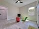 This bedroom features a ceiling fan, and gray wood-look floors, and a tv for entertainment at 10218 Garden Alcove Dr, Tampa, FL 33647