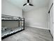 This bedroom features a bunk bed, neutral walls, and modern ceiling fan and light grey wood-look floors at 10218 Garden Alcove Dr, Tampa, FL 33647