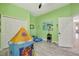 ' room featuring a play tent, light wood flooring, closet and lime green paint at 10218 Garden Alcove Dr, Tampa, FL 33647