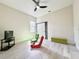 This bedroom features a ceiling fan, and gray wood-look floors, and a tv for entertainment at 10218 Garden Alcove Dr, Tampa, FL 33647