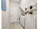 Laundry room featuring a front loading washer and dryer, decorative shelving, and white walls at 10218 Garden Alcove Dr, Tampa, FL 33647