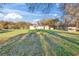 Exterior view of a home, complemented by a large grassy front yard and mature trees at 1051 Hawthorn St, Zephyrhills, FL 33540