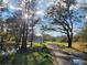 Scenic view of a home behind a pond, surrounded by lush greenery and mature trees, highlighting the natural setting at 1051 Hawthorn St, Zephyrhills, FL 33540