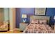 Inviting bedroom with blue walls, decorative bed linens, and a comfortable armchair at 1102 Old Mill Pond Rd, Palm Harbor, FL 34683