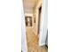 Hallway with herringbone-patterned wood floors leading to bedrooms and updated artwork at 1102 Old Mill Pond Rd, Palm Harbor, FL 34683