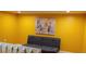 Bright living room with yellow walls, modern art, and gray futon for a welcoming, versatile space at 1102 Old Mill Pond Rd, Palm Harbor, FL 34683
