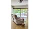 Comfortable living room with a recliner, sliding glass doors, and access to the outdoor deck at 1102 Old Mill Pond Rd, Palm Harbor, FL 34683