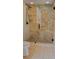 Shower with seamless glass door and natural stone tile and a shower bench at 1102 Old Mill Pond Rd, Palm Harbor, FL 34683