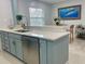 Bright kitchen featuring a stainless steel dishwasher and blue cabinets at 1127 King Arthur Ct # 314, Dunedin, FL 34698