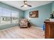 Cozy sitting room featuring a floral armchair, natural light, and wood laminate flooring at 11508 Timber Grove Ln, Brooksville, FL 34613