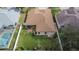 An aerial view shows the backyard, screened in lanai, manicured lawn, and white privacy fence at 1220 Emerald Hill Way, Valrico, FL 33594