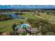 Aerial view of clubhouse with pool, sports court, and nearby golf course and lake at 1220 Emerald Hill Way, Valrico, FL 33594