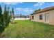 The back yard has well-manicured lawn, a privacy fence, and a view of the neighboring pool at 1220 Emerald Hill Way, Valrico, FL 33594
